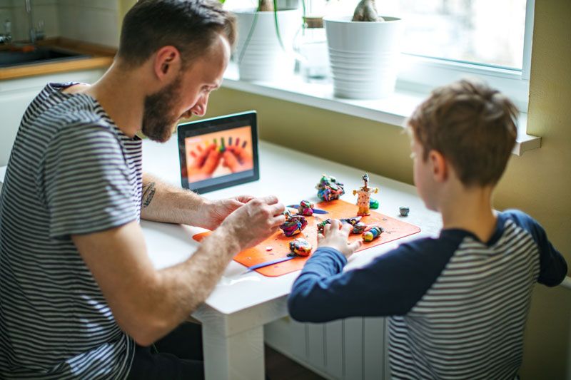 Father and son watching a YouTube video on a tablet to help create models