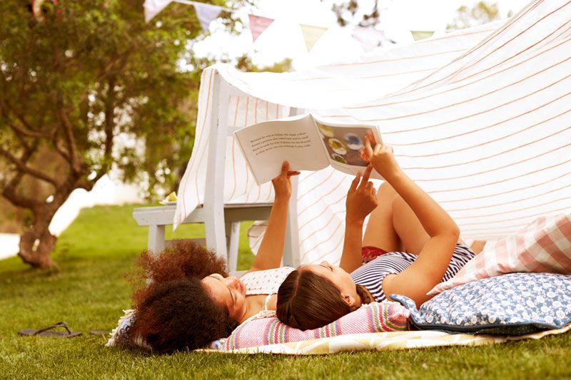 Mother and daughter outside reading a book