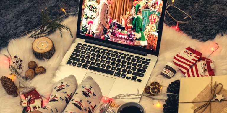 Streaming Christmas Movie on laptop with Christmas decorations and presents background