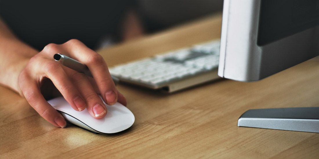 ladies hand using a white mouse on a computer
