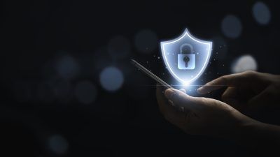 A secure padlock floating above someone using a mobile phone at home