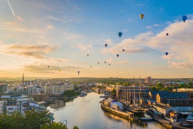 A photo of hot-air balloons flying over the city centre of Bristol