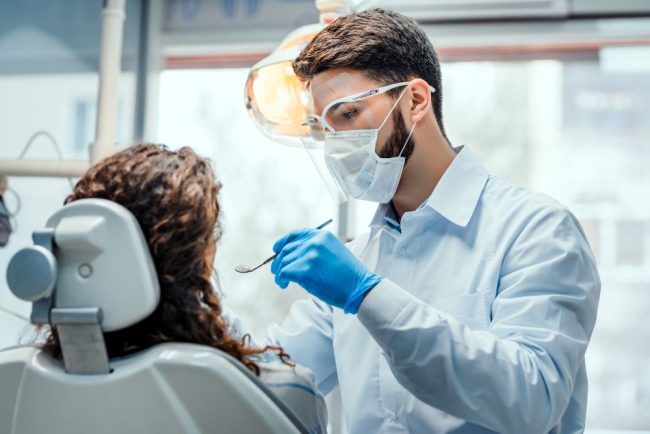 A dentist performing a check up on a patients mouth