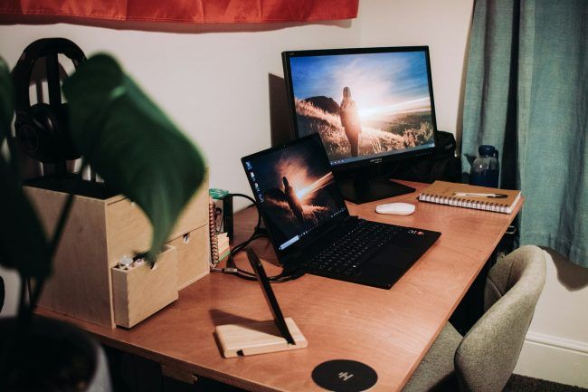 a desk setup for working from home. There is a laptop and an extra monitor