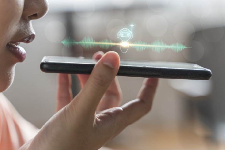 Close up of a woman holding in hand smart phone talking with digital assistant
