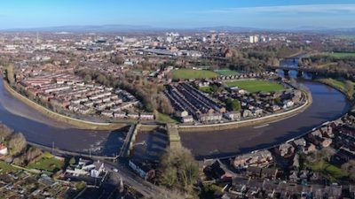 An aerial view of a river and houses on the outskirts of Preston